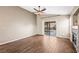 Spacious living room featuring wood-look tile floors and glass sliding door leading to the backyard at 5804 Sassa St, Las Vegas, NV 89130