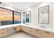 Bright bathroom featuring double sinks, modern cabinetry, and a large picture window with views at 591 Overlook Rim Dr, Henderson, NV 89012