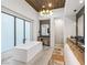 Bright bathroom featuring a soaking tub, chandelier, and stylish vanity at 591 Overlook Rim Dr, Henderson, NV 89012