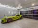 Sleek garage with bright lighting, epoxy floors and glass door showcasing a luxury green sports car at 591 Overlook Rim Dr, Henderson, NV 89012