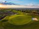 Breathtaking aerial view of a meticulously maintained golf course with rolling green hills at sunset at 591 Overlook Rim Dr, Henderson, NV 89012