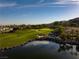 Picturesque golf course featuring a pond, a small waterfall, and lush green landscaping at 591 Overlook Rim Dr, Henderson, NV 89012