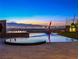 Luxurious infinity pool with sculpture and built-in fire pit overlooking the Las Vegas city lights at 591 Overlook Rim Dr, Henderson, NV 89012