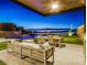 Elegant outdoor living space with a pool, dining area, and city views at twilight at 591 Overlook Rim Dr, Henderson, NV 89012