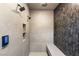 Modern shower with dual shower heads, gray tile, and a built-in bench at 591 Overlook Rim Dr, Henderson, NV 89012