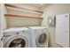 Bright laundry room, washer, dryer, and shelving at 5993 Lambert Bridge Ave, Las Vegas, NV 89139