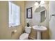 Small powder room with pedestal sink, toilet and decorative accents at 5993 Lambert Bridge Ave, Las Vegas, NV 89139