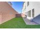 Backyard with artificial turf, brick privacy wall, and grilling area at 7075 Jasper Hill Way, Las Vegas, NV 89118