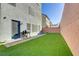 Low maintenance backyard with artificial turf, a brick privacy wall, and a grilling area at 7075 Jasper Hill Way, Las Vegas, NV 89118