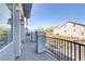 The open-air balcony provides a relaxing space overlooking neighboring houses and a clear blue sky at 7075 Jasper Hill Way, Las Vegas, NV 89118