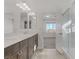 Bathroom featuring a walk-in shower with clear doors, double vanity, and bright lighting at 7075 Jasper Hill Way, Las Vegas, NV 89118
