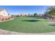 Artificial turf lawn in a community space with bordering shrubs and townhomes visible in the background at 7075 Jasper Hill Way, Las Vegas, NV 89118