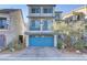 Two-story home with gray siding, blue garage door, and landscaped front yard at 7075 Jasper Hill Way, Las Vegas, NV 89118