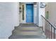 Modern blue front door and a stone stairway leading to the entrance at 7075 Jasper Hill Way, Las Vegas, NV 89118