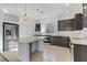 Modern kitchen with dark cabinets, island, and stainless steel appliances at 7075 Jasper Hill Way, Las Vegas, NV 89118