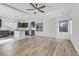 Open-concept living area with wood flooring, modern lighting and large windows at 7075 Jasper Hill Way, Las Vegas, NV 89118