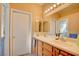 Double vanity bathroom with wood cabinets and large mirror at 7741 Orchard Wood Ct, Las Vegas, NV 89131