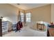 Well-lit bedroom with carpeted floor, window, and workspace at 7741 Orchard Wood Ct, Las Vegas, NV 89131