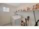 Well-lit laundry room with washer, dryer, and shelving at 8035 Skye Foxx St, Las Vegas, NV 89166