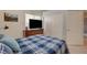 Bedroom with a plaid comforter, TV, and double door closet at 8805 Jeffreys St # 1032, Las Vegas, NV 89123