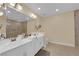 Bathroom featuring double sinks, a large mirror, and a glass-enclosed shower at 9852 Snowy Canyon Ct, Las Vegas, NV 89183