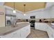 Well-lit kitchen features white cabinets, stainless steel appliances, tile floors and a large island with tile countertop at 9852 Snowy Canyon Ct, Las Vegas, NV 89183