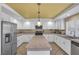 Kitchen with white cabinets, large island and yellow ceiling at 9852 Snowy Canyon Ct, Las Vegas, NV 89183