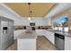 Modern kitchen with stainless steel appliances, central island, and tile countertops at 9852 Snowy Canyon Ct, Las Vegas, NV 89183