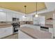 Kitchen with island, white cabinets, and tiled countertops at 9852 Snowy Canyon Ct, Las Vegas, NV 89183