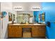 Double vanity bathroom with wood cabinets and a large mirror at 10093 Golden Bluff Ave, Las Vegas, NV 89148