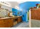 Double vanity bathroom with wood cabinets and blue walls at 10093 Golden Bluff Ave, Las Vegas, NV 89148