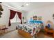 Bright bedroom with a wood platform bed and window curtains at 10093 Golden Bluff Ave, Las Vegas, NV 89148