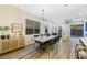 Bright dining room features a large concrete table with dark chairs, hardwood floors, and modern lighting at 10369 Niagara Falls Ln, Las Vegas, NV 89144