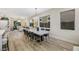 Open concept dining room with concrete table and modern light fixture, hardwood floors, and views into living room at 10369 Niagara Falls Ln, Las Vegas, NV 89144