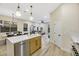 Modern kitchen with island, marble countertops, stainless steel appliances, and light wood cabinets at 10369 Niagara Falls Ln, Las Vegas, NV 89144