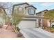 Two-story house with attached garage, landscaping, and driveway at 10810 Hunters Green Ave, Las Vegas, NV 89166