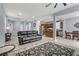 Open floor plan living room with a gray couch, kitchen, and dining area at 10810 Hunters Green Ave, Las Vegas, NV 89166