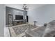 Living room with gray walls, dark wood floors, and a large TV at 10810 Hunters Green Ave, Las Vegas, NV 89166