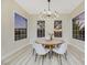 Spacious dining room with large windows, hardwood floors, and a modern chandelier at 1928 Oliver Springs St, Henderson, NV 89052