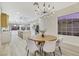 Open concept dining area with a large wooden table, chandelier, and views to the kitchen at 1928 Oliver Springs St, Henderson, NV 89052