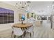 Modern dining room features a round table, chandelier, and views into a spacious kitchen at 1928 Oliver Springs St, Henderson, NV 89052