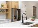 Stylish kitchen island with black faucet and large stainless steel refrigerator at 1928 Oliver Springs St, Henderson, NV 89052