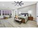 Spacious primary bedroom with a king-size bed, modern ceiling fan, and stylish mid-century furniture at 1928 Oliver Springs St, Henderson, NV 89052