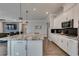 Modern kitchen with white cabinets, granite countertops, and a large island at 2469 Cingoli St, Henderson, NV 89044