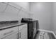 Laundry room with granite countertop, white cabinets, and shelving at 2469 Cingoli St, Henderson, NV 89044