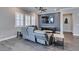 Living room with gray reclining sofas, wood-look floors, and a large TV at 2469 Cingoli St, Henderson, NV 89044