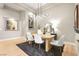 Modern dining room with light wood table and statement chandelier at 3016 Darby Falls Dr, Las Vegas, NV 89134