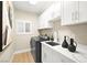 Bright laundry room featuring white cabinets and modern appliances at 3016 Darby Falls Dr, Las Vegas, NV 89134