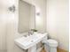 Modern powder room with white sink, toilet and stylish mirror at 3016 Darby Falls Dr, Las Vegas, NV 89134