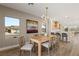 Bright dining room features a wood table with seating for six and large windows at 3110 Scotts Valley Dr, Henderson, NV 89052